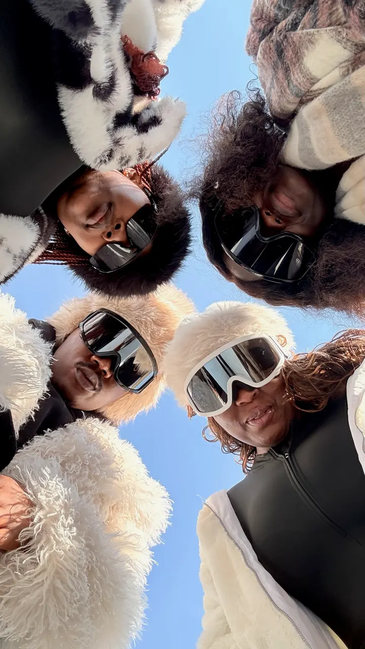 Four friends in ski goggles taking a selfie in the snow in Lesotho